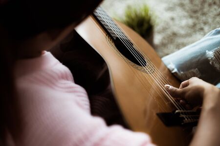 A beautiful asian woman playing acoustic guitarの写真素材