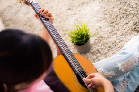 A beautiful asian woman playing acoustic guitarの写真素材