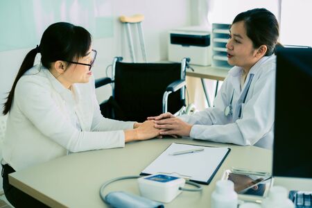 Hand of doctor reassuring her female patientの写真素材