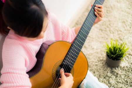 A beautiful asian woman playing acoustic guitarの写真素材