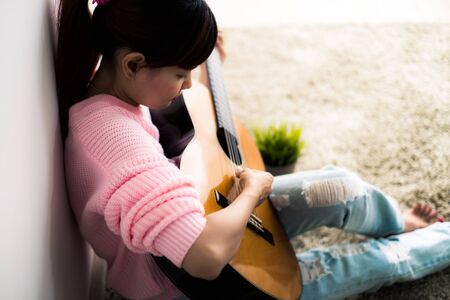 A beautiful asian woman playing acoustic guitarの写真素材