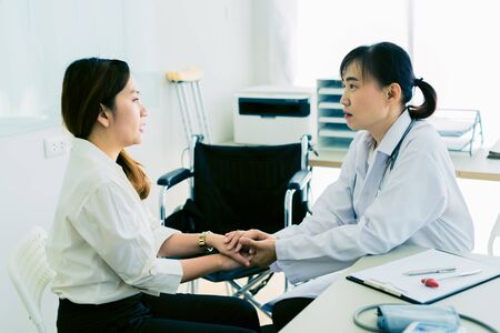Hand of doctor reassuring her female patientの写真素材