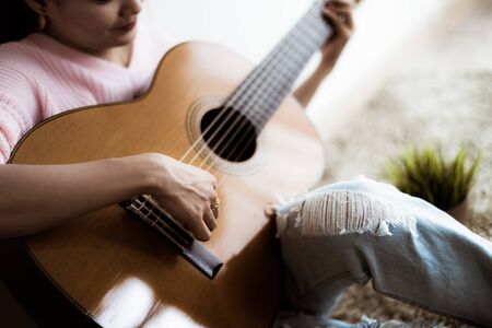 A beautiful asian woman playing acoustic guitarの写真素材