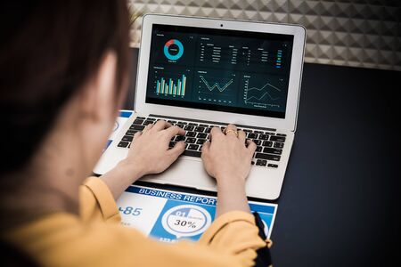 Closeup view of finance market analyst working at office on laptop while sitting at table....