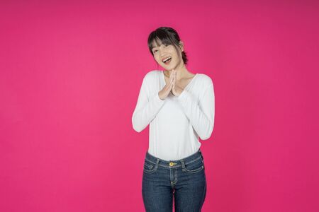 Do not miss. Young asian woman shouting. Shout. Crying emotional  woman screaming on pink studio background. Female half-length portrait. Human emotions, facial expression concept. Trendyの写真素材