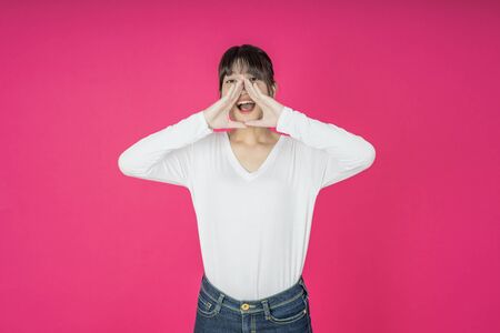 asian young casual style woman portrait isolated over pink background.の写真素材