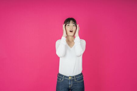 Do not miss. Young asian woman shouting. Shout. Crying emotional  woman screaming on pink studio background. Female half-length portrait. Human emotions, facial expression concept. Trendyの写真素材