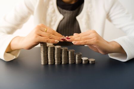 Asian women put coin stack money for money growth concept