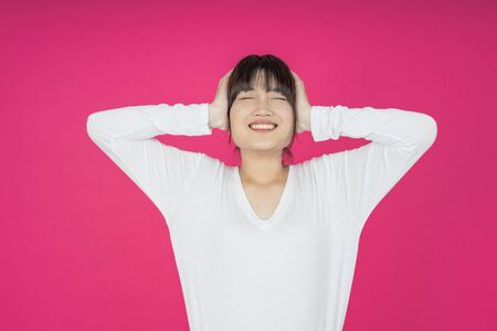 asian young casual style woman portrait isolated over pink background.の写真素材