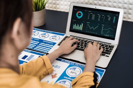 Closeup view of finance market analyst working at office on laptop while sitting at table. Businesswoman analyze stock report on notebook screen.の写真素材