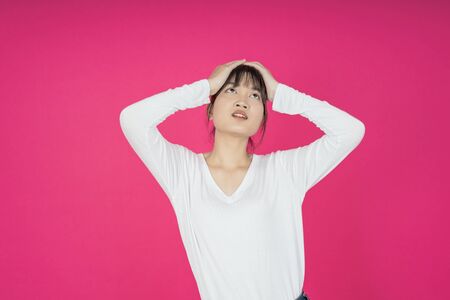 asian young casual style woman portrait isolated over pink background.の写真素材
