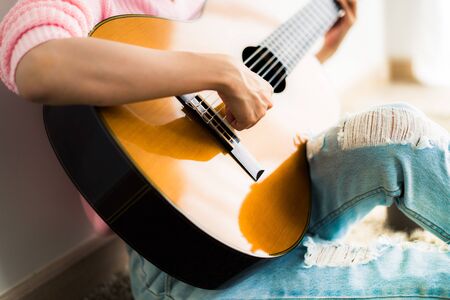 A beautiful asian woman playing acoustic guitarの写真素材