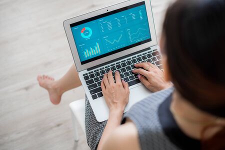 Asian business woman reviewing data in financial charts and graphs. Accountingの写真素材