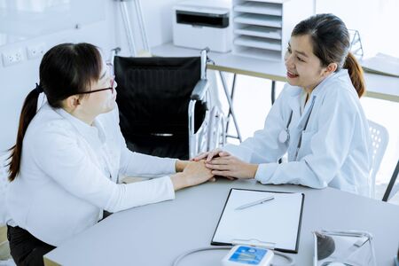 Hand of doctor reassuring her female patientの写真素材