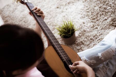 A beautiful asian woman playing acoustic guitarの写真素材