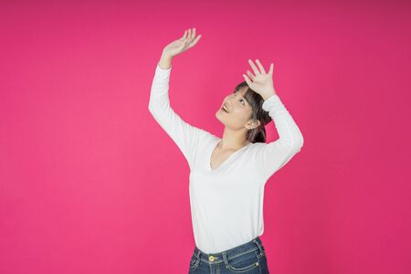 asian young casual style woman portrait isolated over pink background.の写真素材