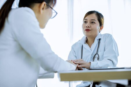 Hand of doctor reassuring her female patientの写真素材