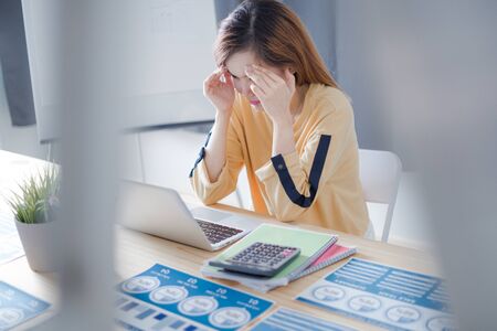 Tired asian woman massaging eyes feeling strain fatigue headache relieving painの写真素材