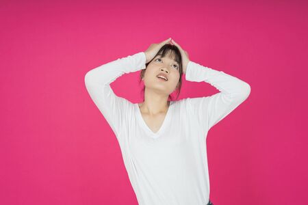 asian young casual style woman portrait isolated over pink background.の写真素材