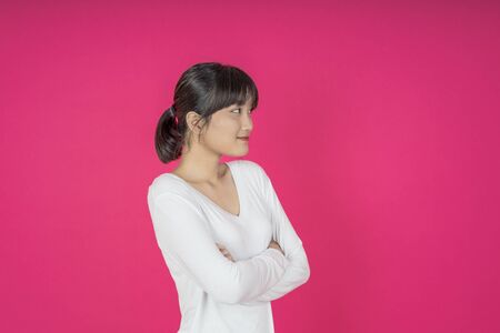 asian young casual style woman portrait isolated over pink background.の写真素材