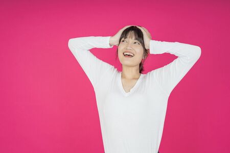 asian young casual style woman portrait isolated over pink background.の写真素材
