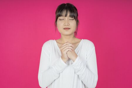 asian young casual style woman portrait isolated over pink background.の写真素材