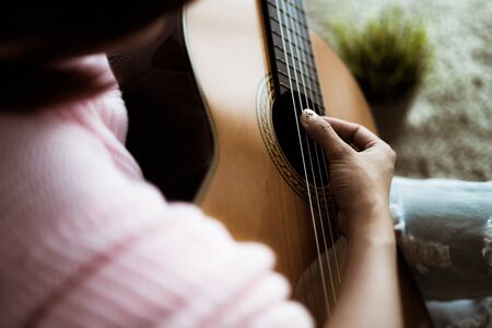 A beautiful asian woman playing acoustic guitarの写真素材