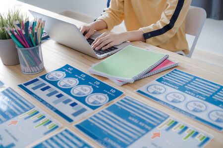 Asian business woman reviewing data in financial charts and graphs. Accountingの写真素材