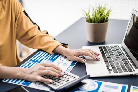 Business women reviewing data in financial charts and graphs. Accountingの写真素材