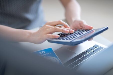 Asian business woman reviewing data in financial charts and graphs. Accountingの写真素材