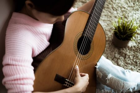 A beautiful asian woman playing acoustic guitarの写真素材