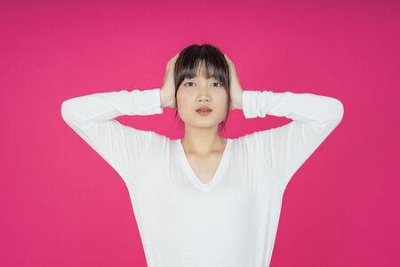 asian young casual style woman portrait isolated over pink background.の写真素材