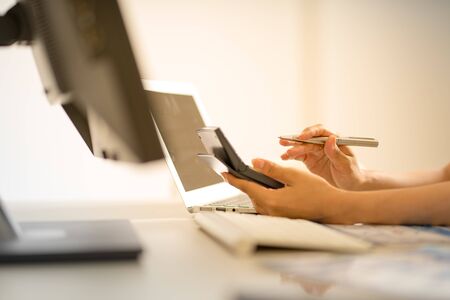 Asian business woman reviewing data in financial charts and graphs. Accountingの写真素材