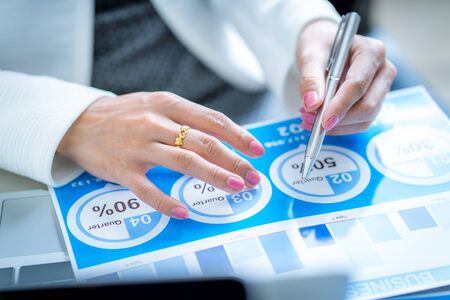 Asian business woman reviewing data in financial charts and graphs. Accountingの写真素材
