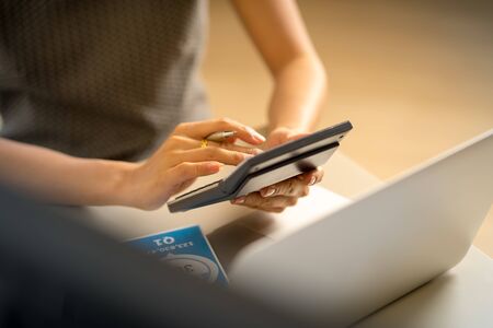 Asian business woman reviewing data in financial charts and graphs. Accountingの写真素材