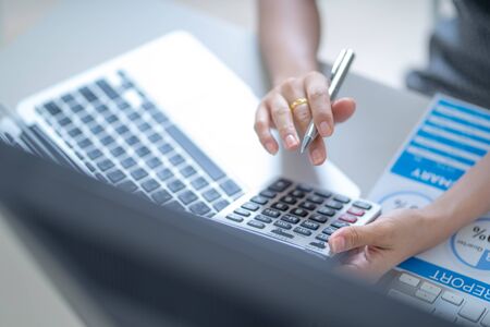 Asian business woman reviewing data in financial charts and graphs. Accountingの写真素材