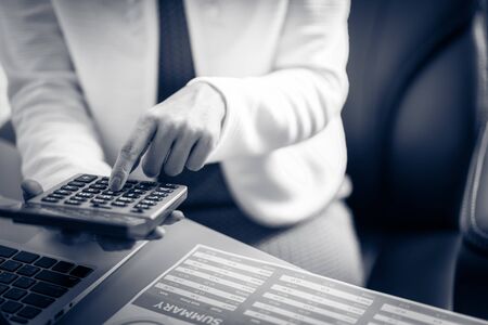 Asian business woman reviewing data in financial charts and graphs. Accountingの写真素材