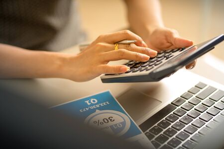 Asian business woman reviewing data in financial charts and graphs. Accountingの写真素材