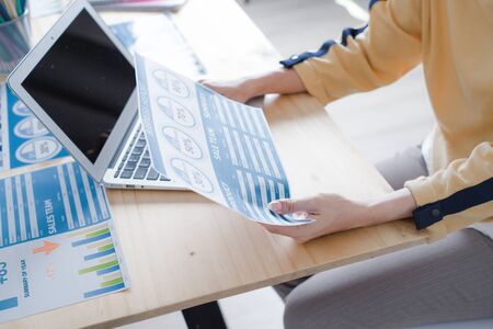 Asian business woman reviewing data in financial charts and graphs. Accountingの写真素材