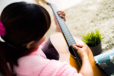 A beautiful asian woman playing acoustic guitarの写真素材