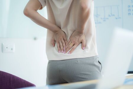 Asian woman with back pain in officeの写真素材