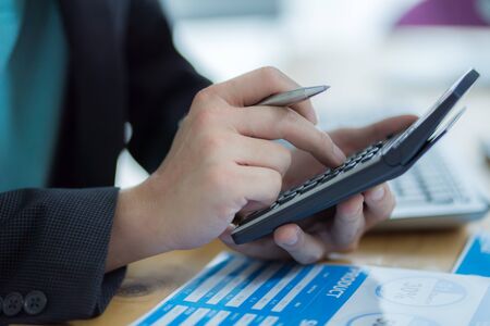 Businessman analyzing investment charts with laptopの写真素材