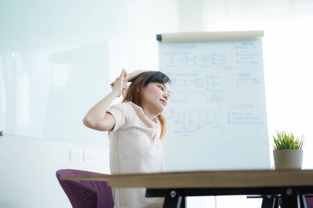 Asian woman with back pain in officeの写真素材
