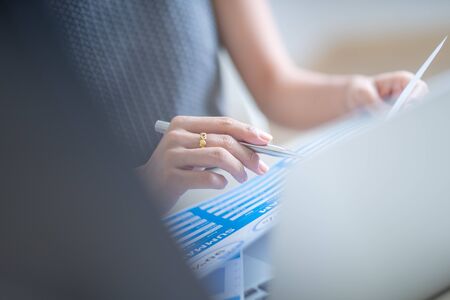 Asian business woman reviewing data in financial charts and graphs. Accountingの写真素材