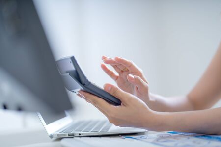 Asian business woman reviewing data in financial charts and graphs. Accountingの写真素材