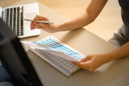 Asian business woman reviewing data in financial charts and graphs. Accountingの写真素材