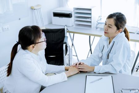 Hand of doctor reassuring her female patientの写真素材