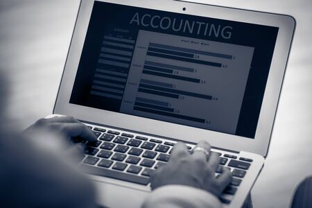 Asian business woman reviewing data in financial charts and graphs. Accountingの写真素材