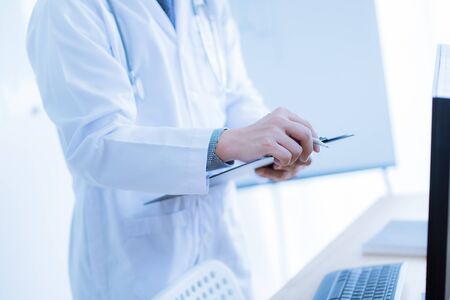 Close-up Of Male Doctor Filling The Medical Formの写真素材
