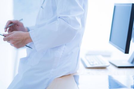 Close-up Of Male Doctor Filling The Medical Formの写真素材